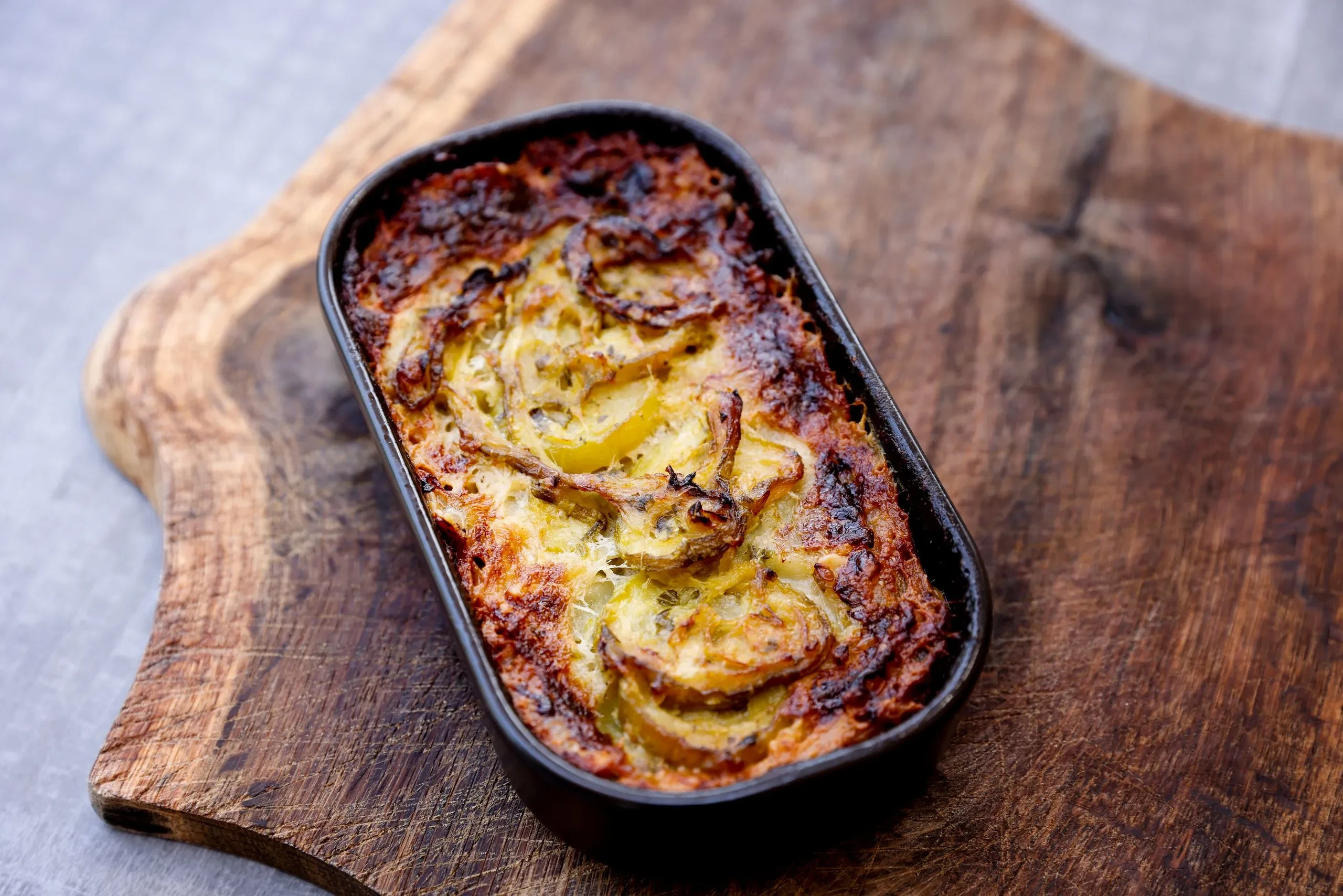 Gratin de pommes de terre doré sur planche en bois - Restaurant Salins les Bains - Domaine La Scierie