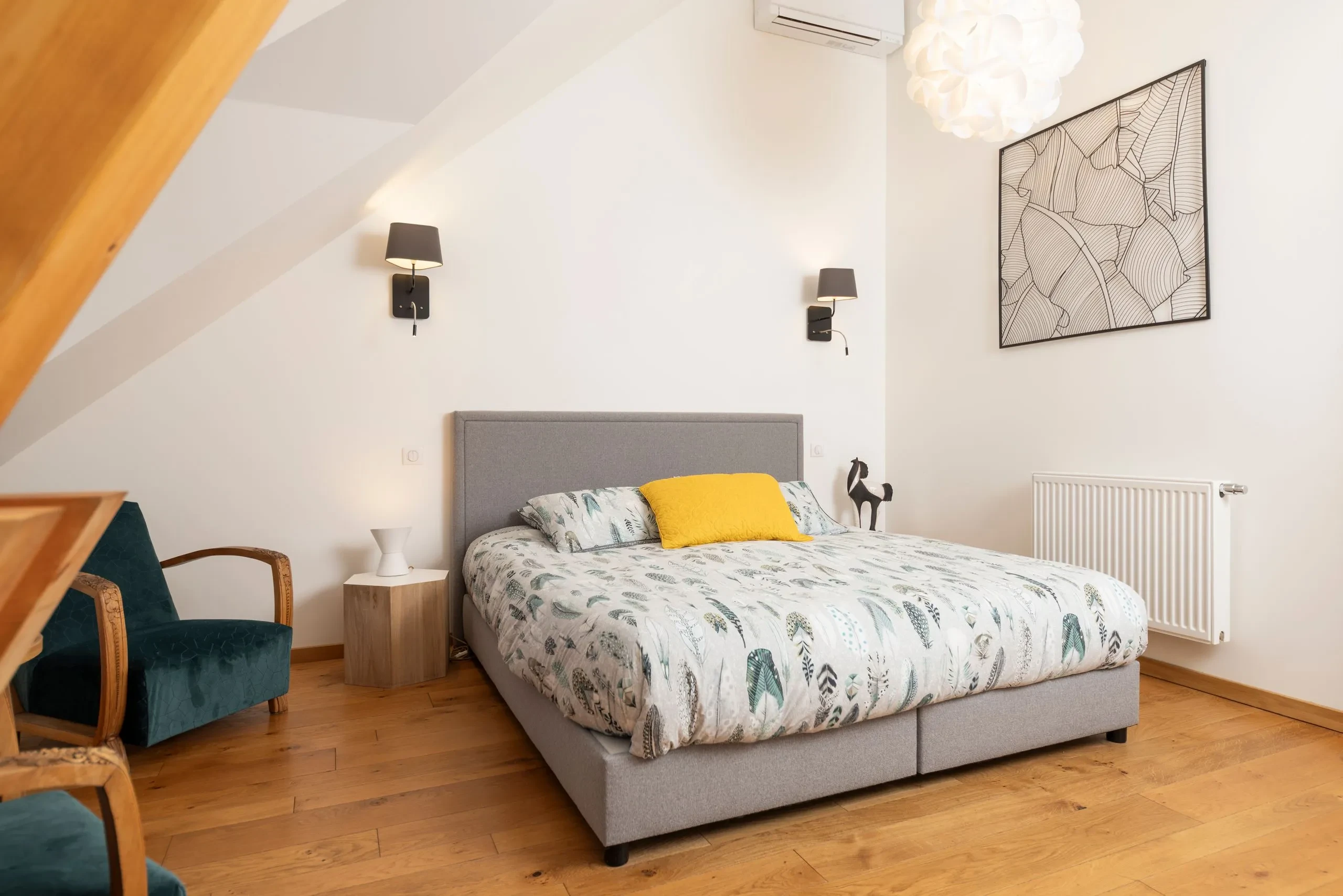 Chambre moderne avec lit gris et déco épurée