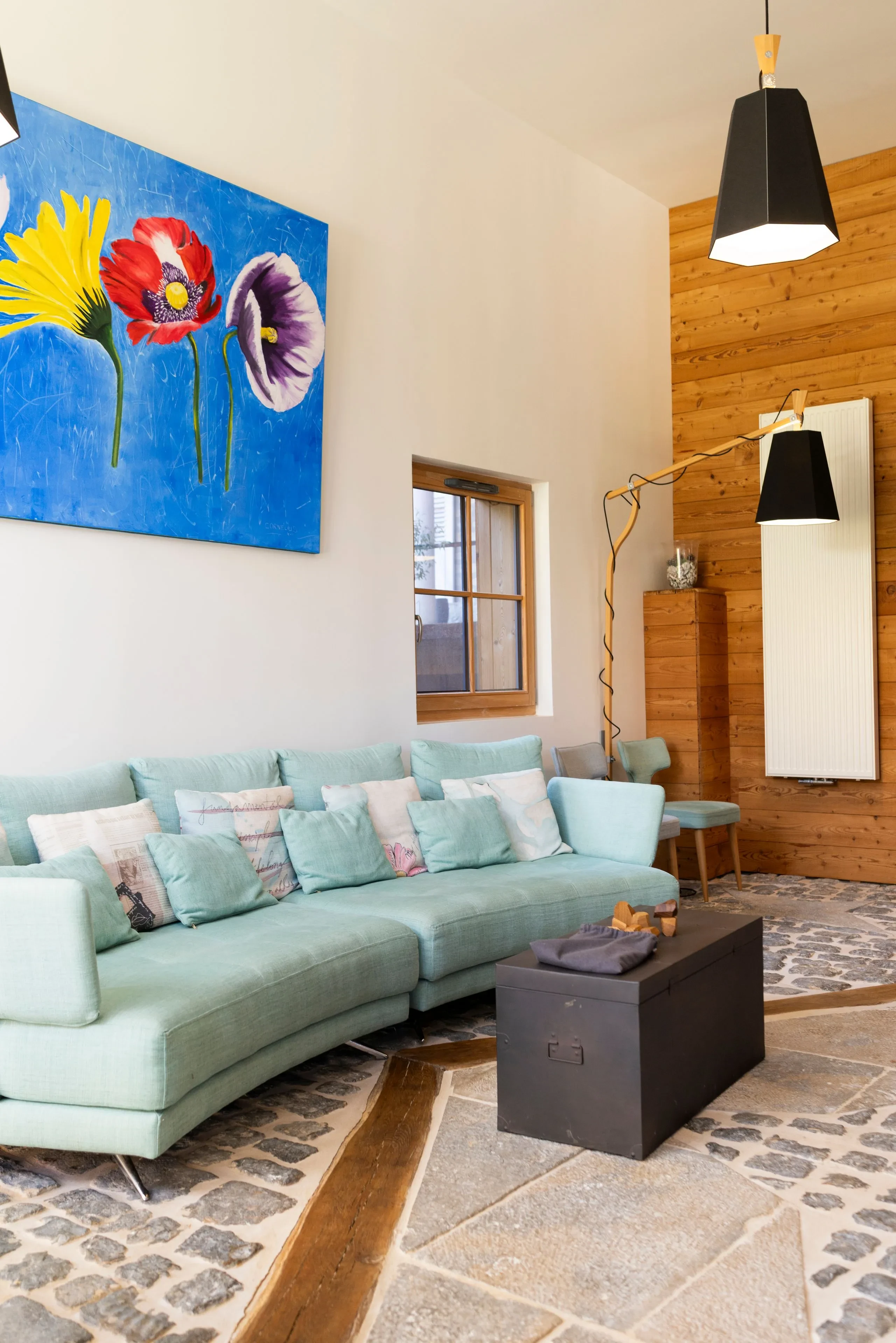 Salon moderne avec canapé turquoise et tableau coloré