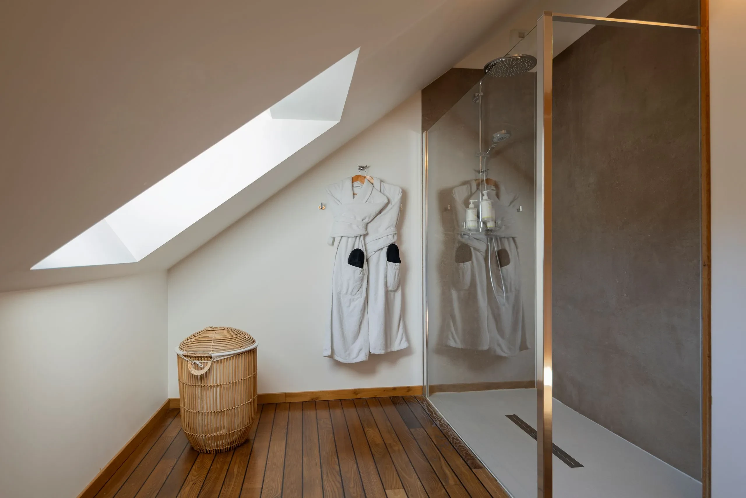 Salle de bain moderne avec douche et peignoirs accrochés
