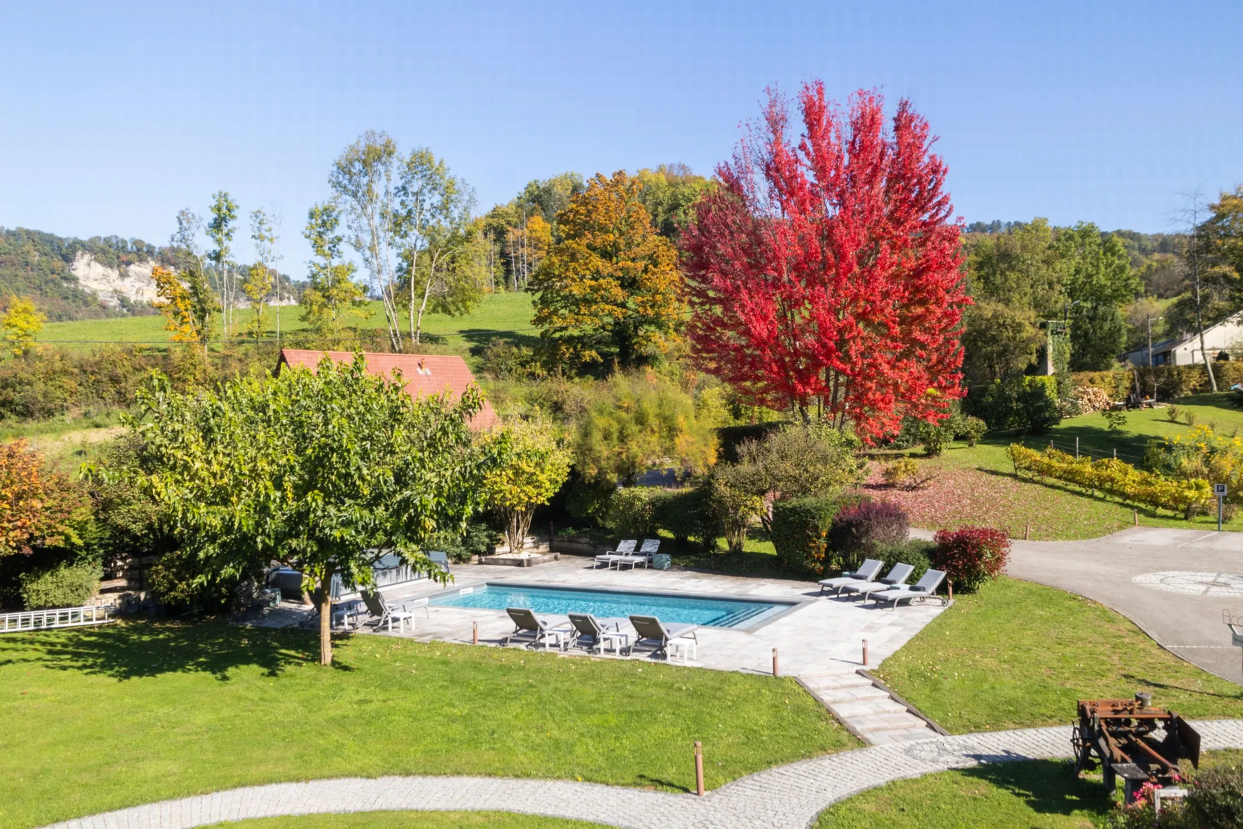Jardin verdoyant avec piscine et arbres colorés - Spa Jura - Domaine La Scierie