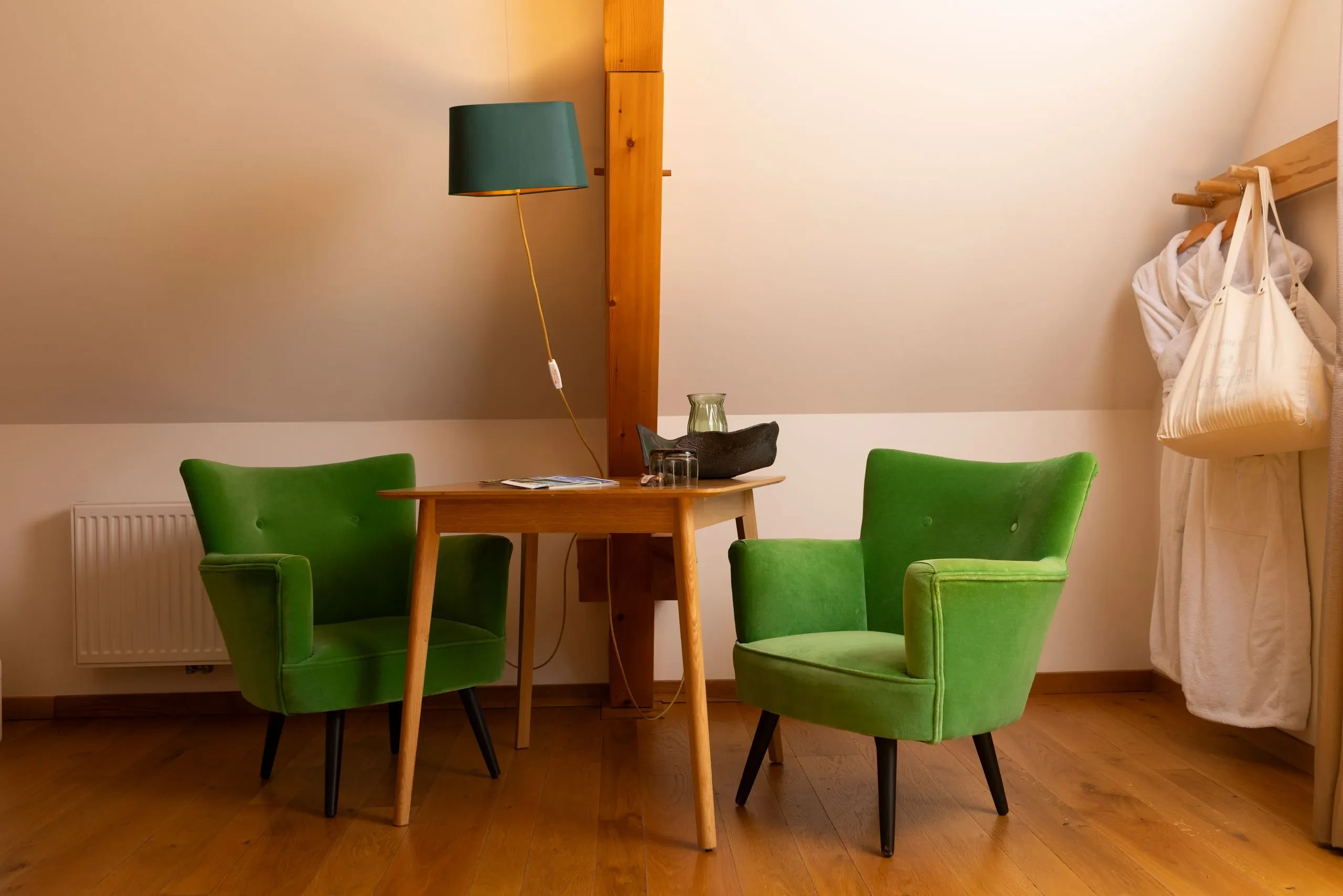 Coin salon avec deux fauteuils verts et table en bois - Chambre d'hôtes Jura - Domaine La Scierie