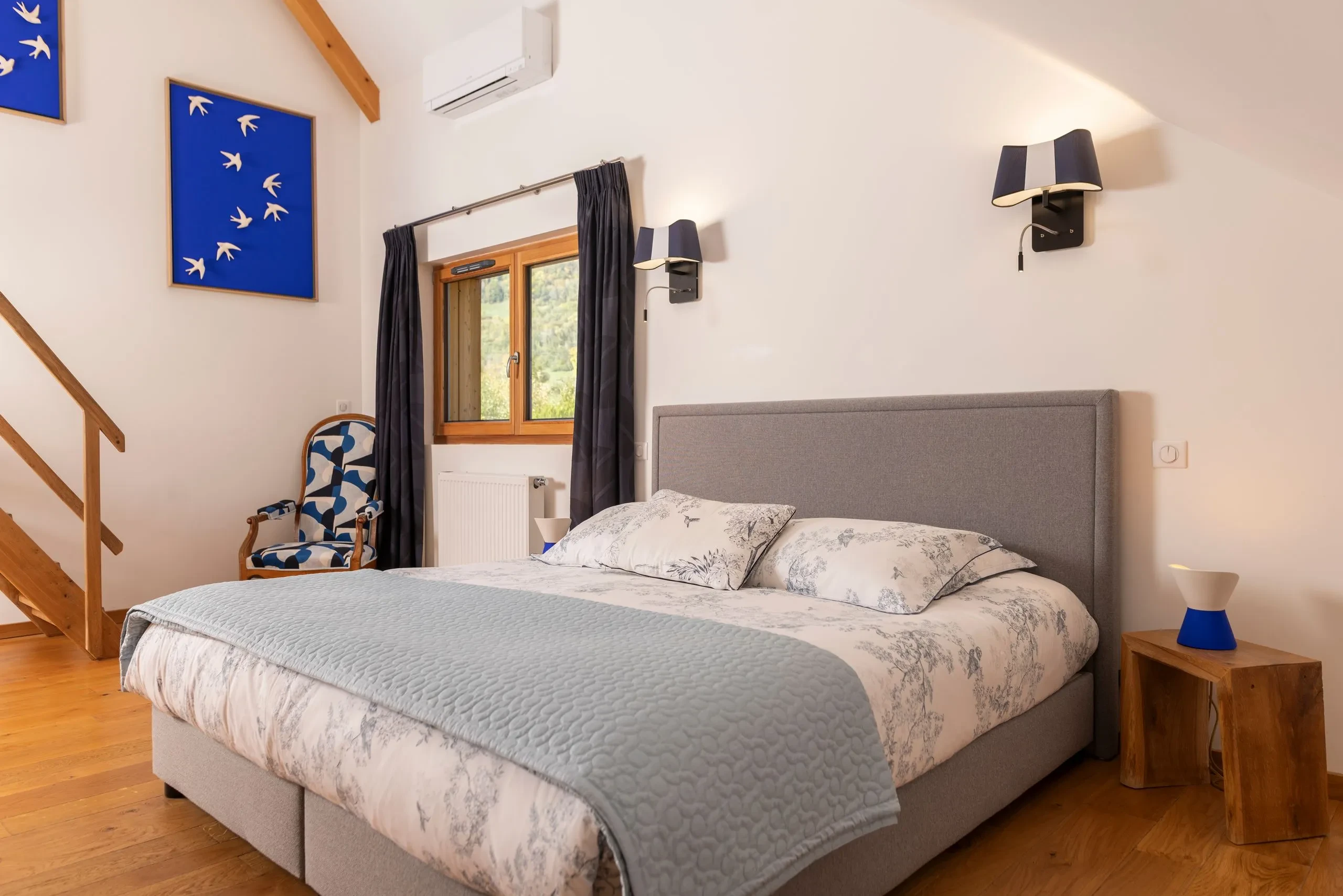 Chambre moderne avec lit gris et décoration bleue