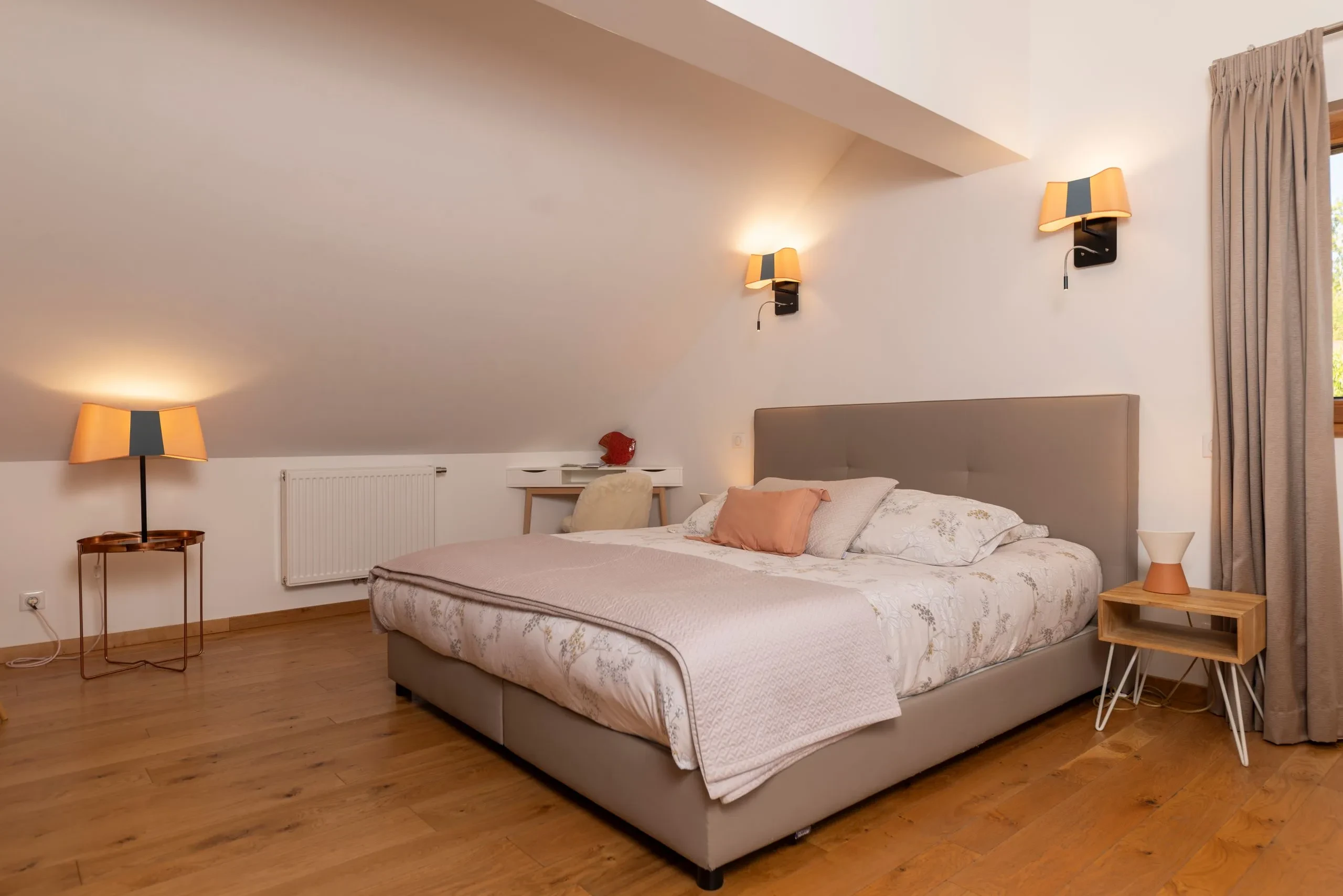 Chambre mansardée moderne avec lit double et lampes