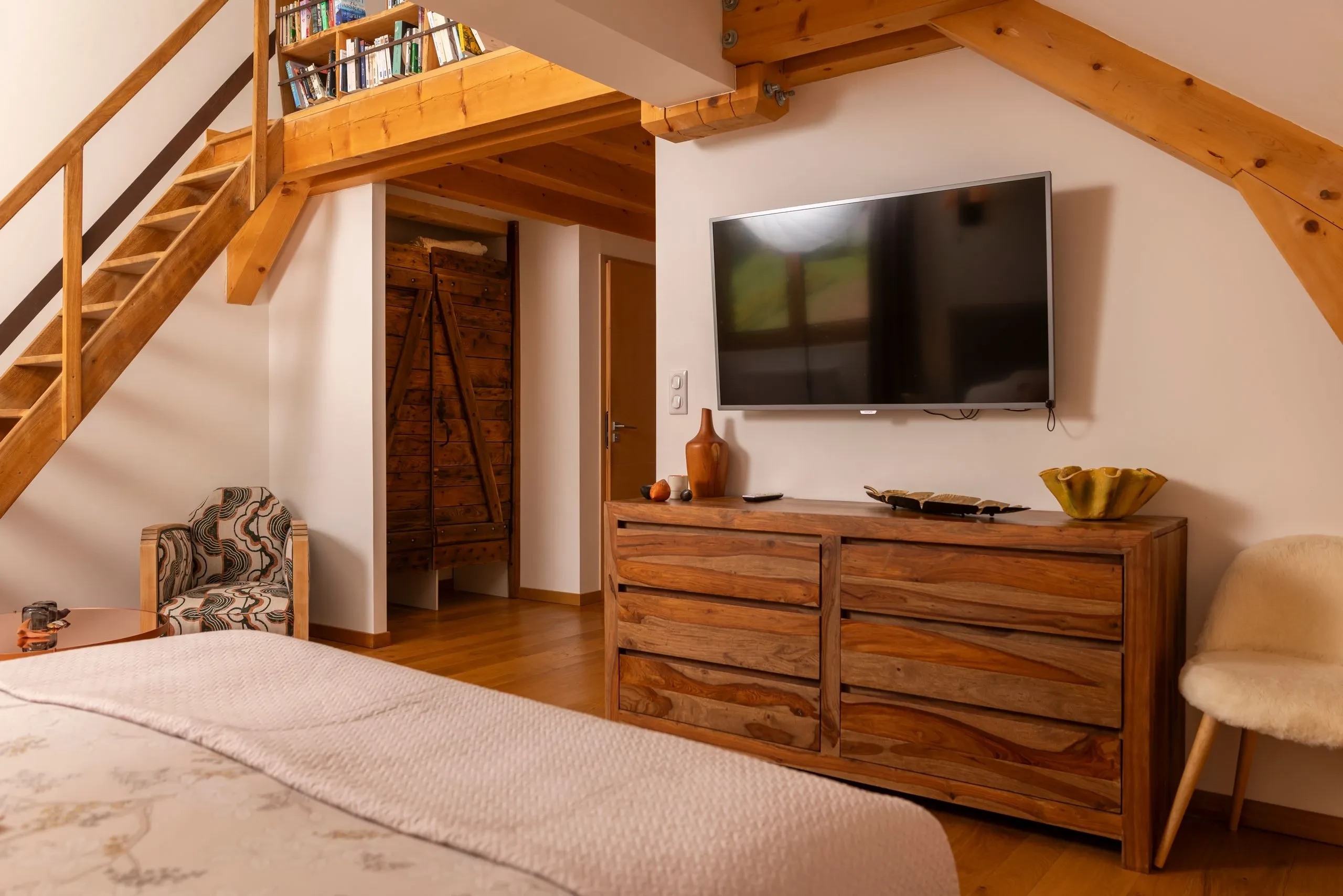 Chambre en bois avec mezzanine et télévision murale
