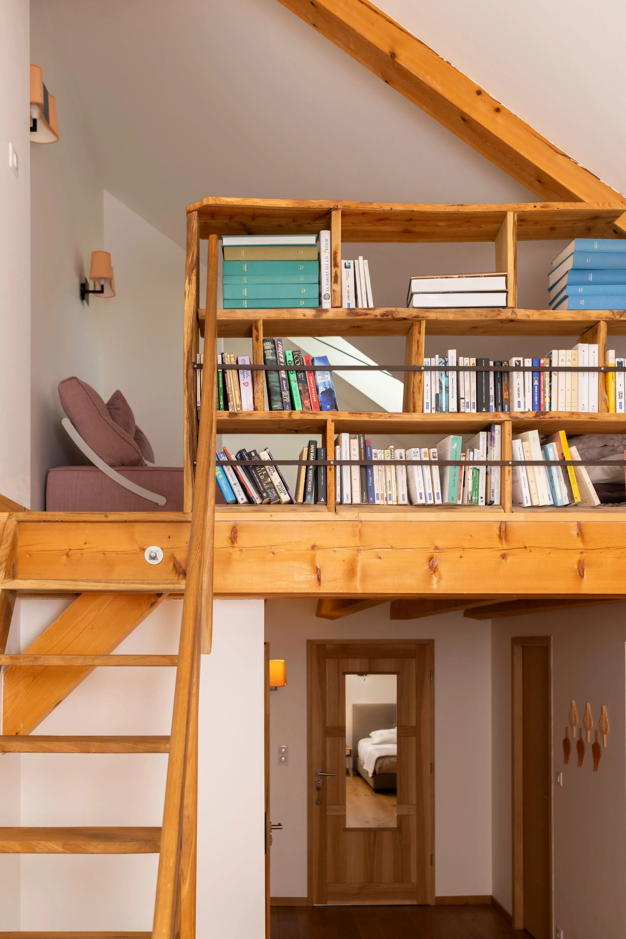 Mezzanine en bois avec bibliothèque et fauteuil
