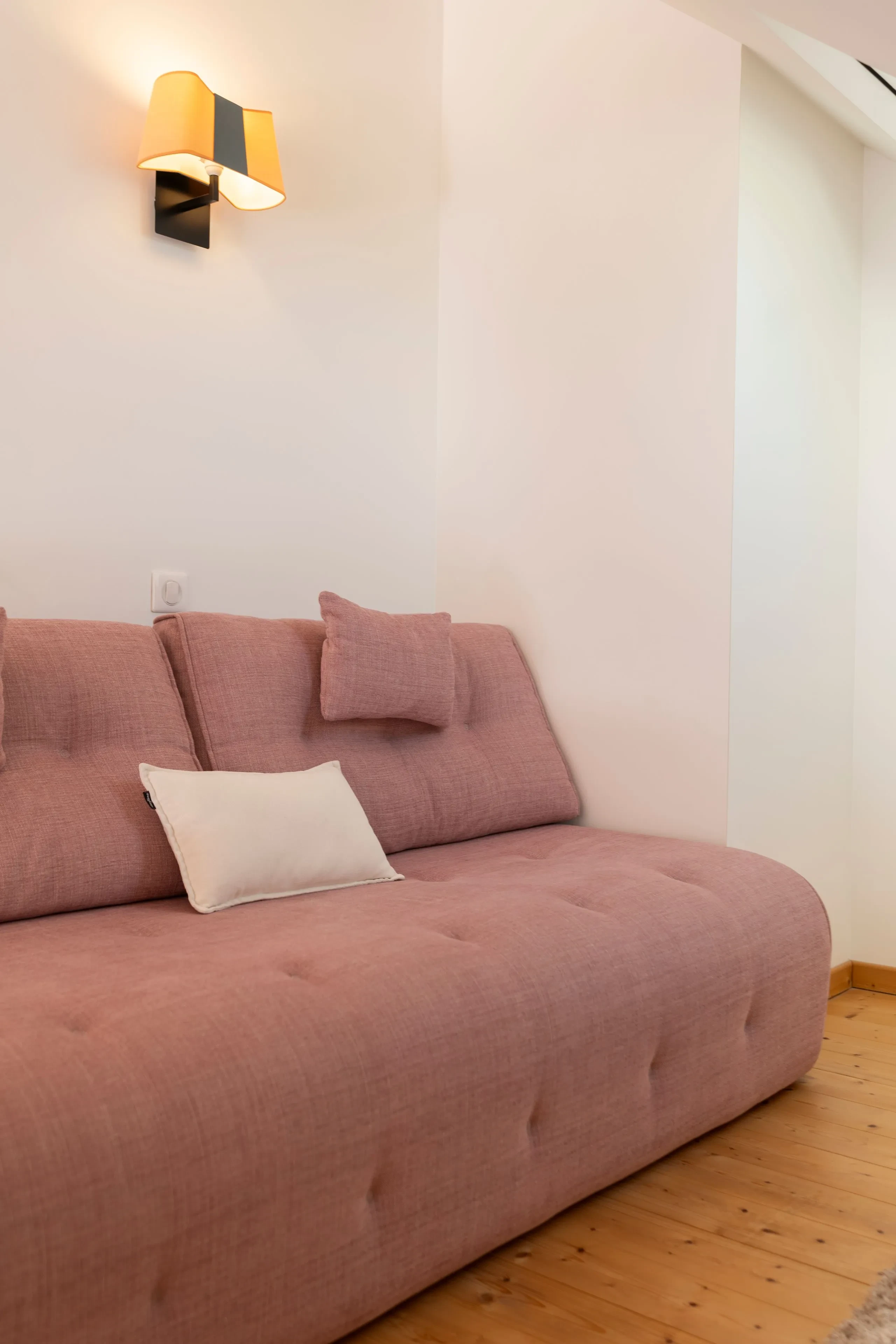 Canapé rose avec coussins dans salon lumineux