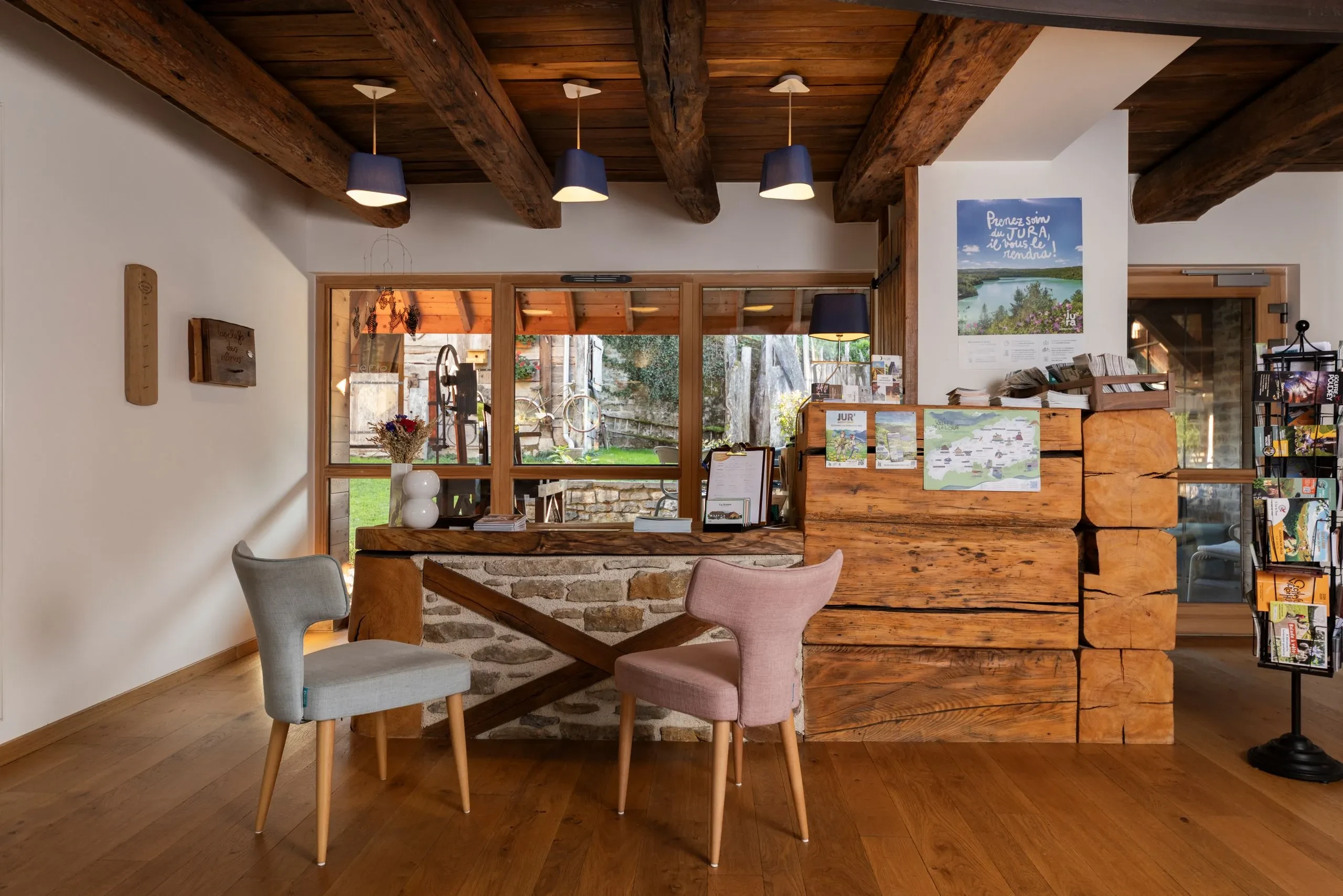 Accueil en bois chaleureux avec chaises et brochures touristiques
