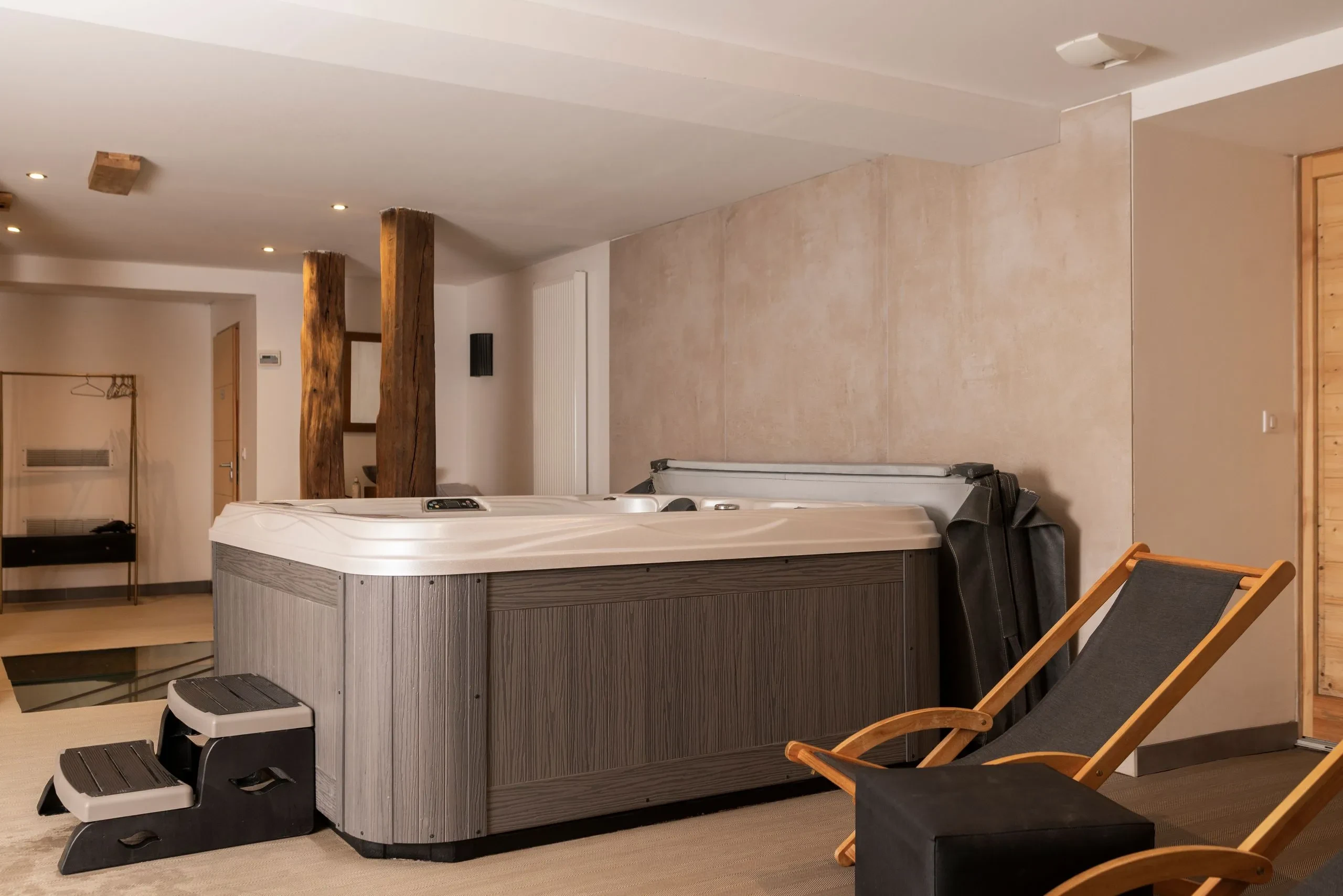 Salle de spa avec jacuzzi et chaises longues - Hôtel spa jura - Domaine la Scierie