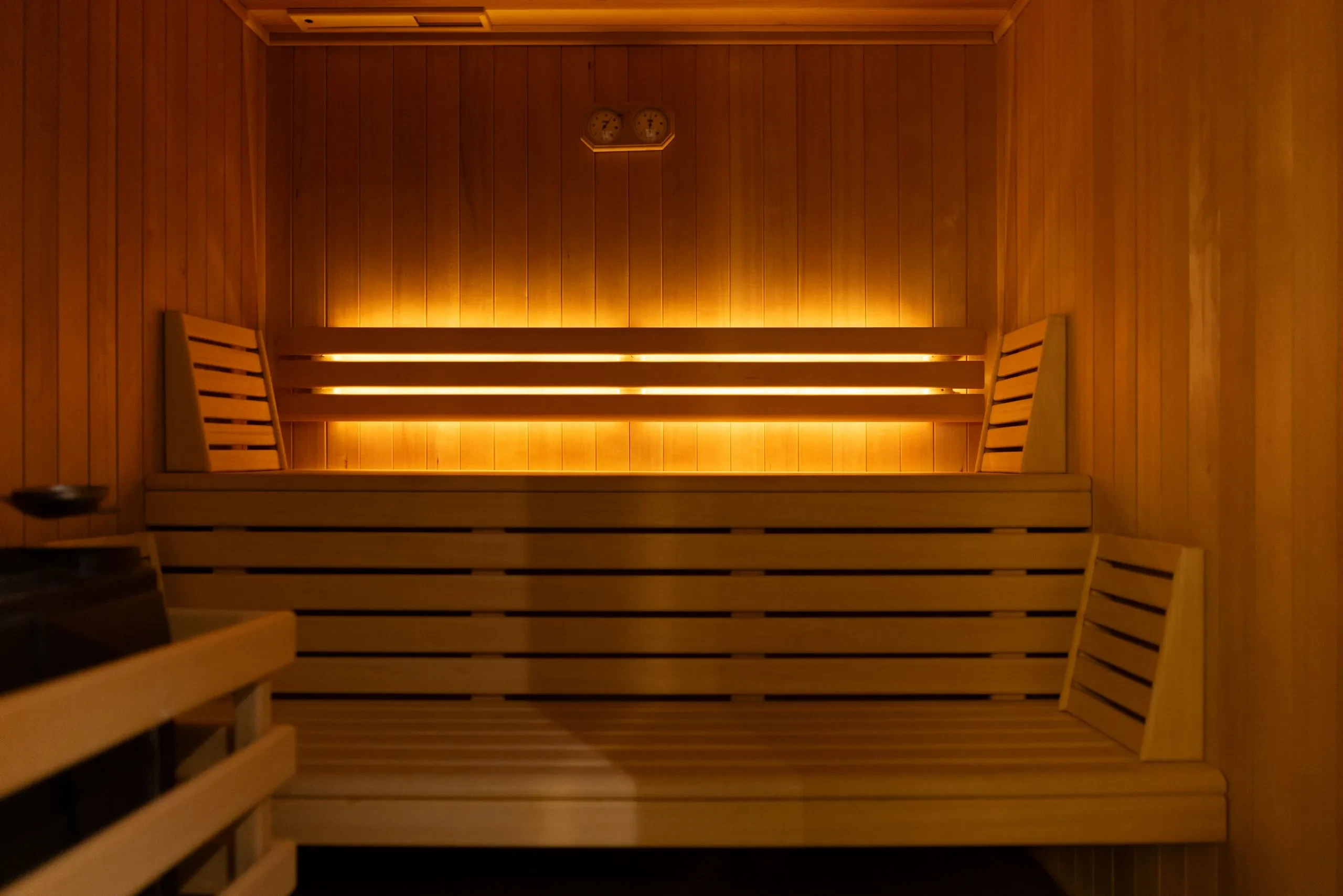 Intérieur en bois d’un sauna éclairé chaudement - Chambre d'hôtes Salins les Bains - Domaine La Scierie