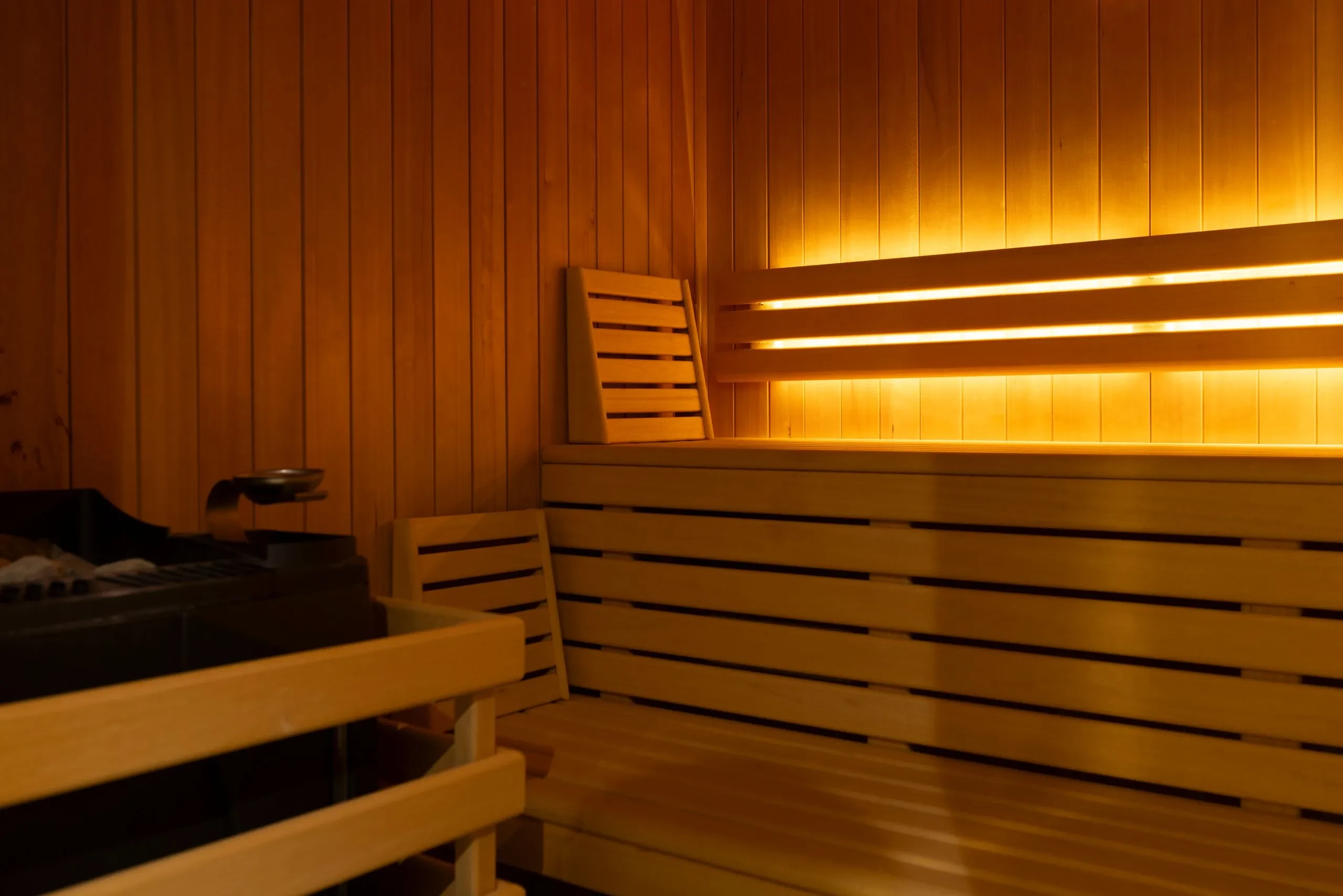 Intérieur chaleureux d’un sauna en bois illuminé - Spa Jura - Domaine La Scierie