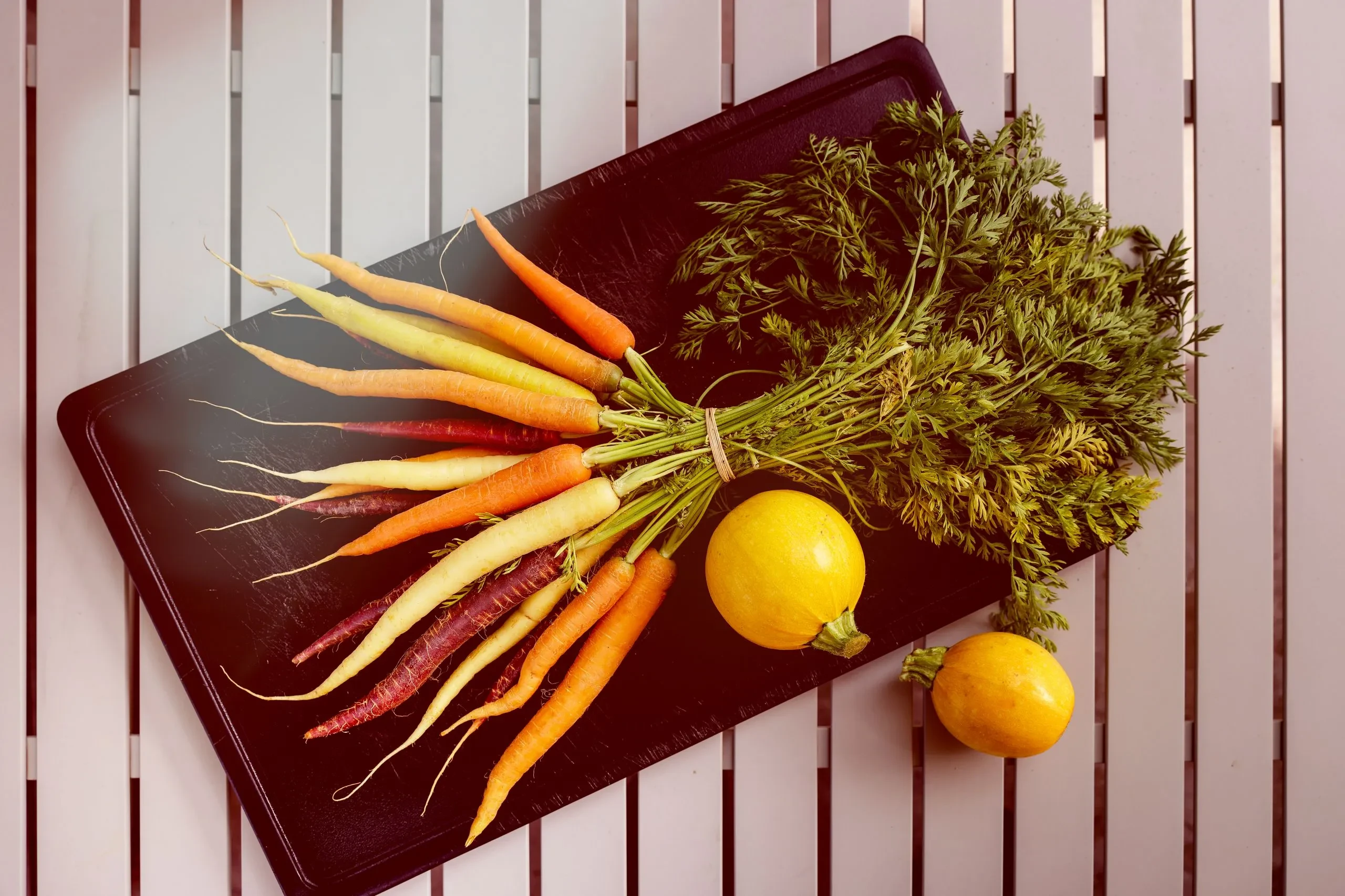 Carottes colorées et courgettes jaunes sur planche noire - Restaurant Salins les Bains - Domaine La Scierie