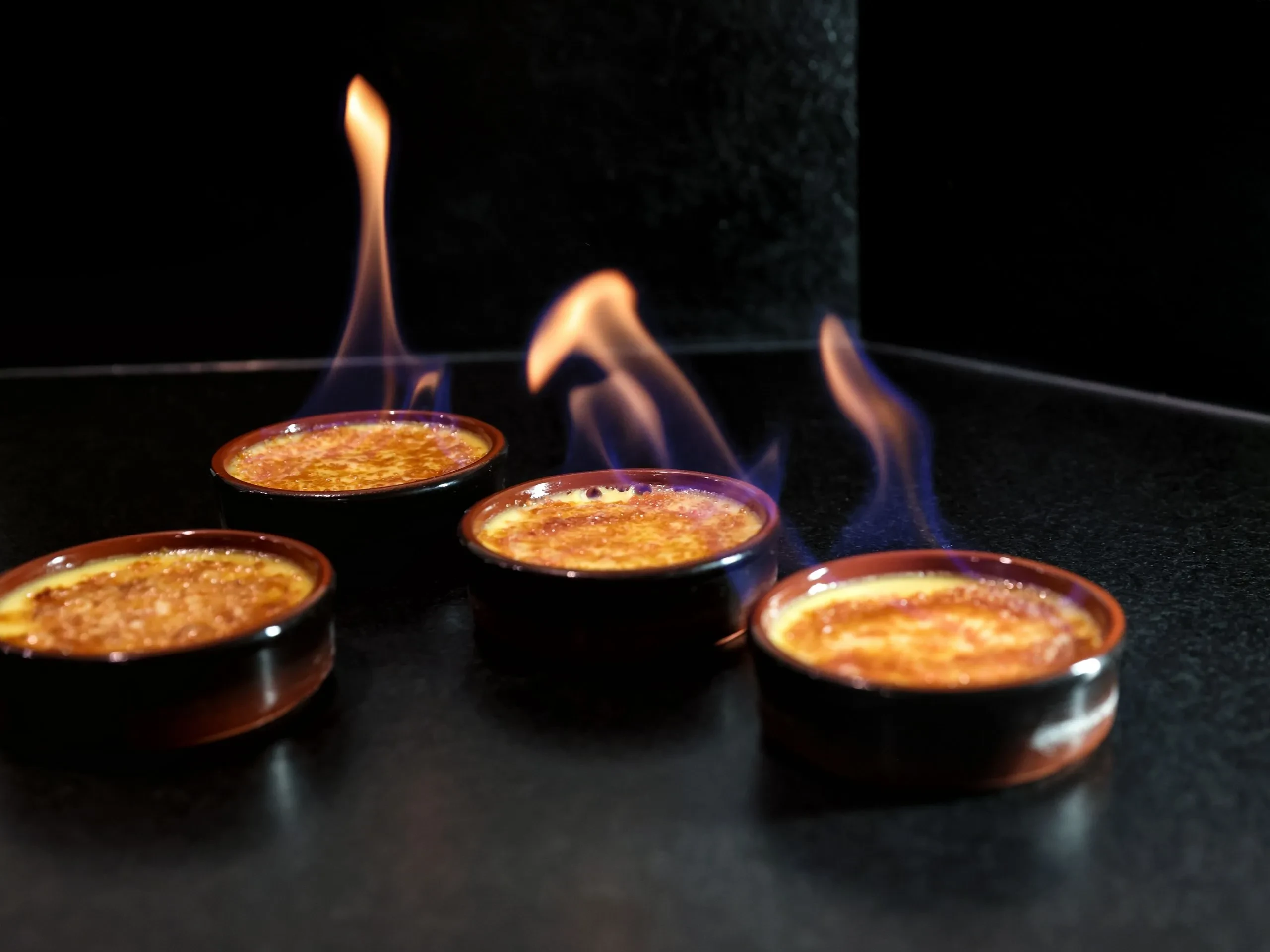 Crèmes brûlées flambées sur plan de travail sombre - Chambre d'hôtes Salins les Bains - Domaine La Scierie