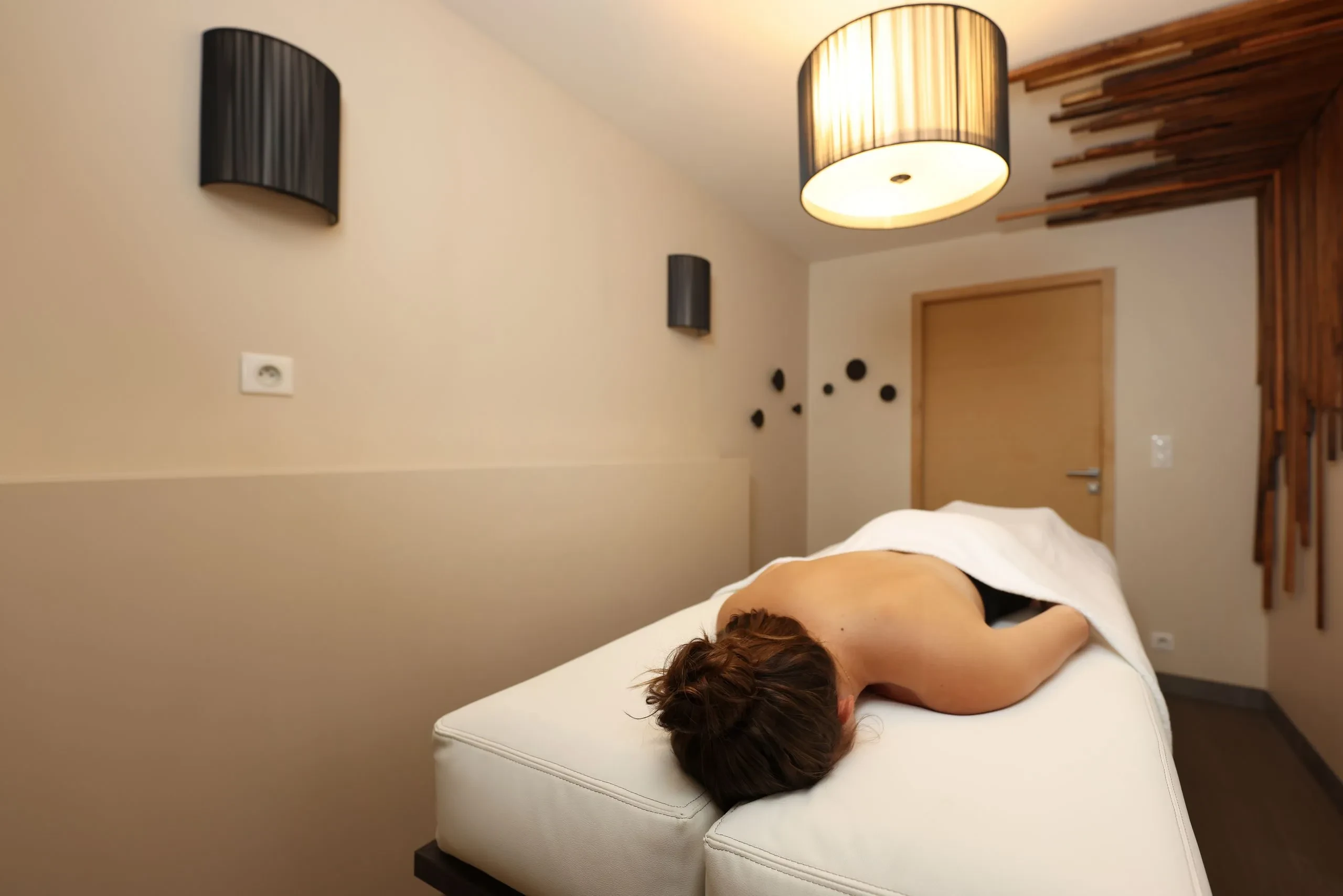 Personne détendue allongée sur une table de massage - Spa privatif Jura - Domaine la Scierie